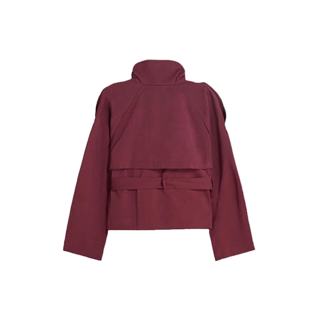 Back view of cropped trench coat on model, showcasing structured silhouette and epaulet detail